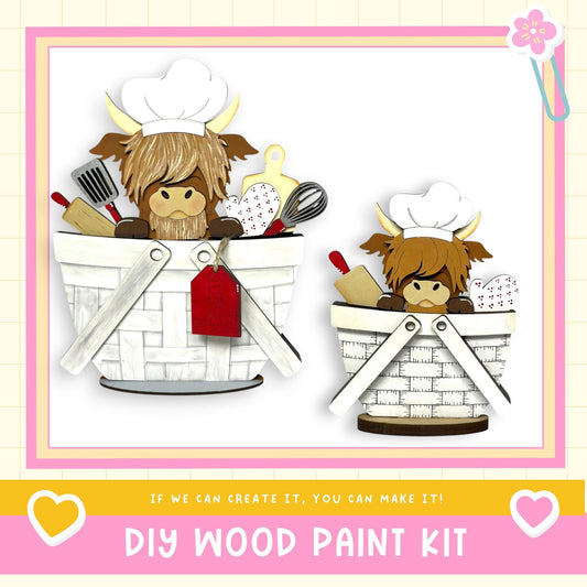 two wooden baskets, each containing a cartoon cow wearing a chef's hat. The baskets are filled with various kitchen utensils, such as spoons and a whisk. The image also includes text that reads "DIY WOOD PAINT KIT" and "IF WE CAN CREATE IT, YOU CAN MAKE IT!"