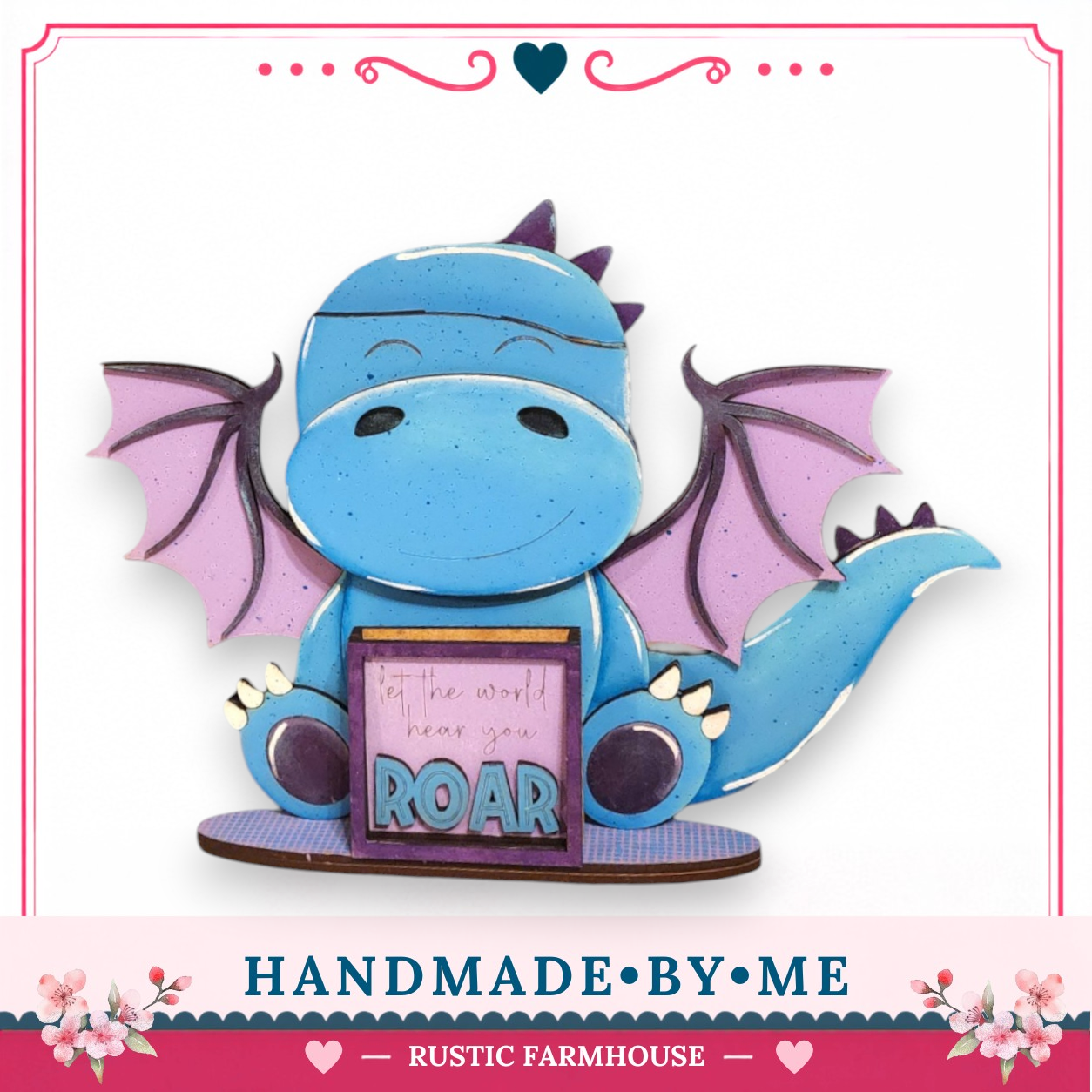 A handcrafted wooden dragon figurine holding a sign that says "Let the world hear you Roar".
