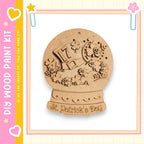 A wooden snow globe with a decorative design, including a hat, flowers, and the text "St. Patrick's Day".