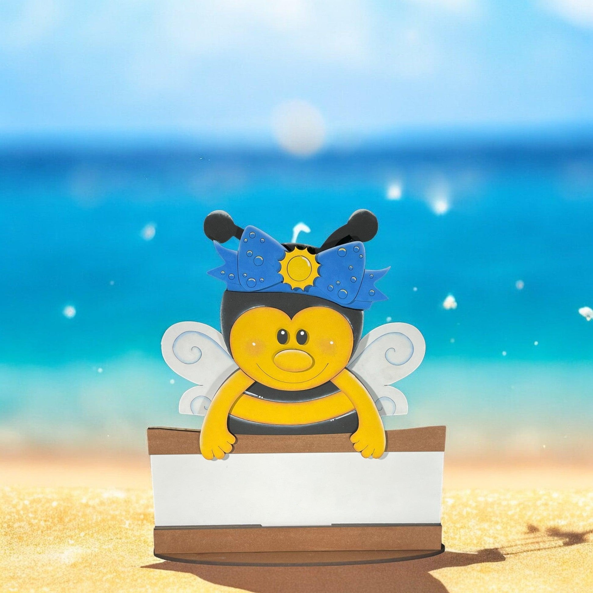 a paper cut out of a bee on a beach