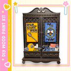 The image is a wooden paint kit featuring a decorative cabinet with various items and text.