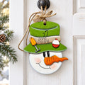A snowman decoration with a fishing hat and a carrot nose, hanging on a door.