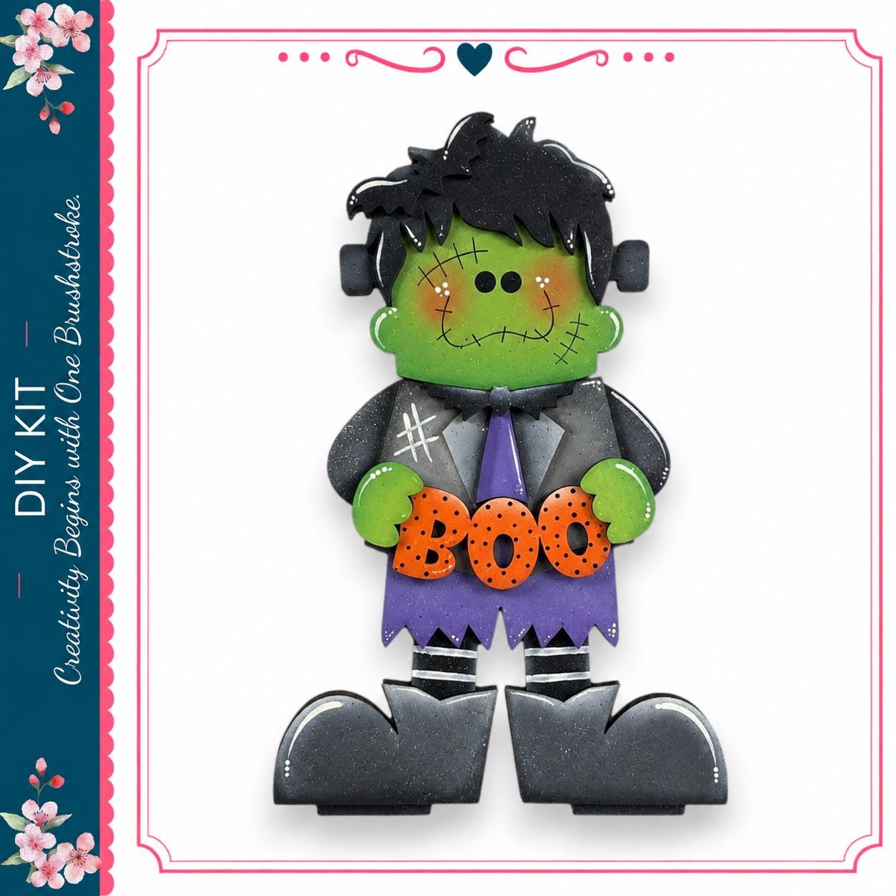 A Halloween-themed DIY kit featuring a green-skinned, green-haired, and green-shirted character holding a "Boo" sign.