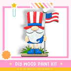 a wooden gnome wearing a red, white, and blue hat and holding an American flag, with a DIY wood paint kit and the text "DIY WOOD PAINT KIT" displayed.