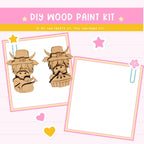 The image is a DIY wood paint kit featuring two wooden characters, likely representing a boy and a girl, with a blank space for painting. The kit appears to be designed for children, with a playful and creative theme.