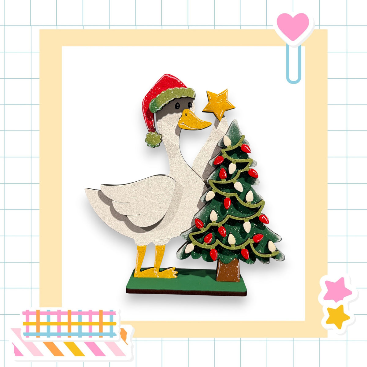 A wooden duck wearing a Santa hat is decorating a Christmas tree with lights and a star.