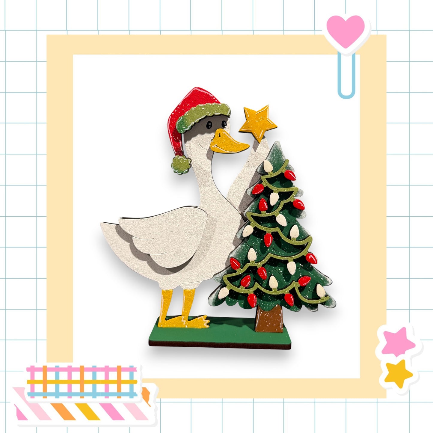 A wooden duck wearing a Santa hat is decorating a Christmas tree with lights and a star.