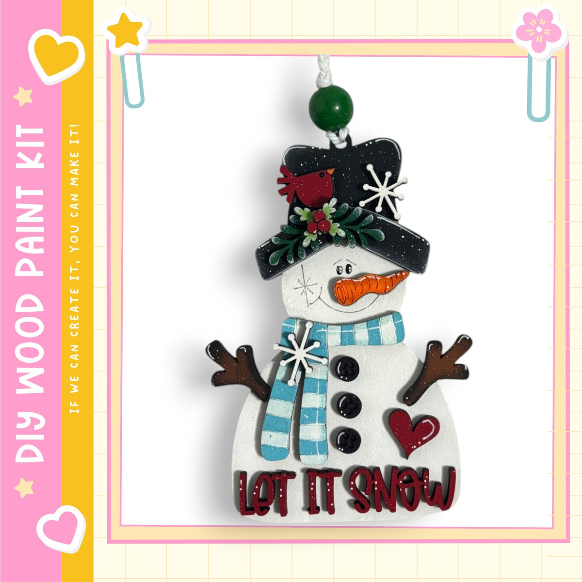 A snowman ornament with a hat, scarf, and carrot nose, along with the text "LET IT SNOW" on its body.