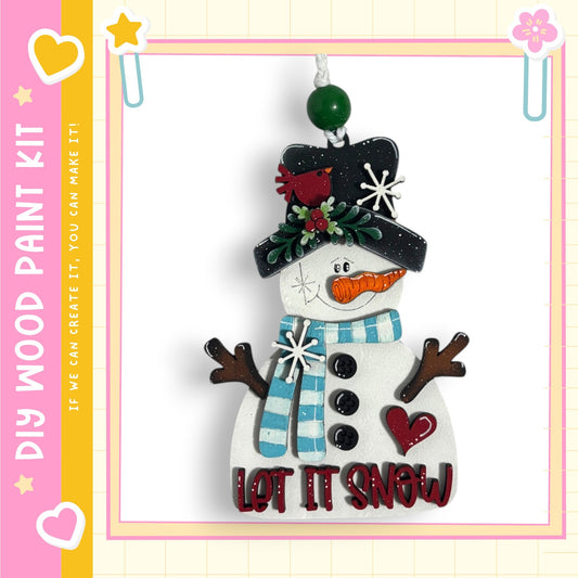 A snowman ornament with a hat, scarf, and carrot nose, along with the text "LET IT SNOW" on its body.