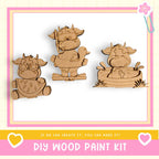three wooden animal figures, including a cow, a duck, and a horse, arranged in a row. The text below the image reads "DIY WOOD PAINT KIT" and "If we can create it, you can make it!"