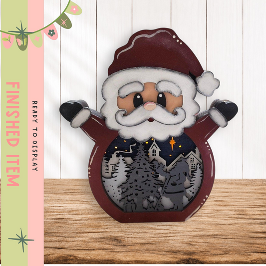 A wooden Santa Claus figurine with a snow globe containing a winter scene inside, placed on a wooden surface.