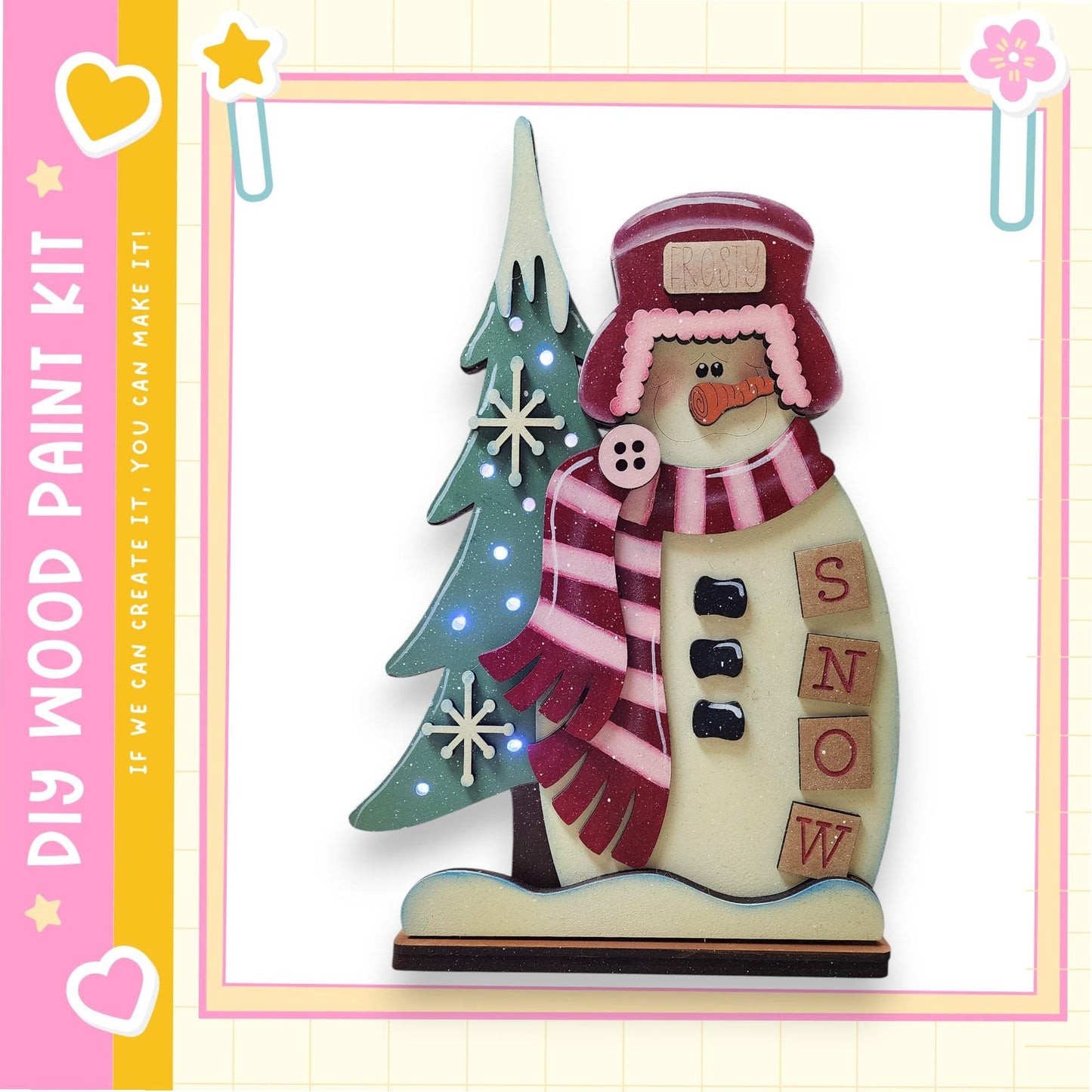 A wooden snowman figure with a red hat, scarf, and buttons, standing next to a decorated Christmas tree.