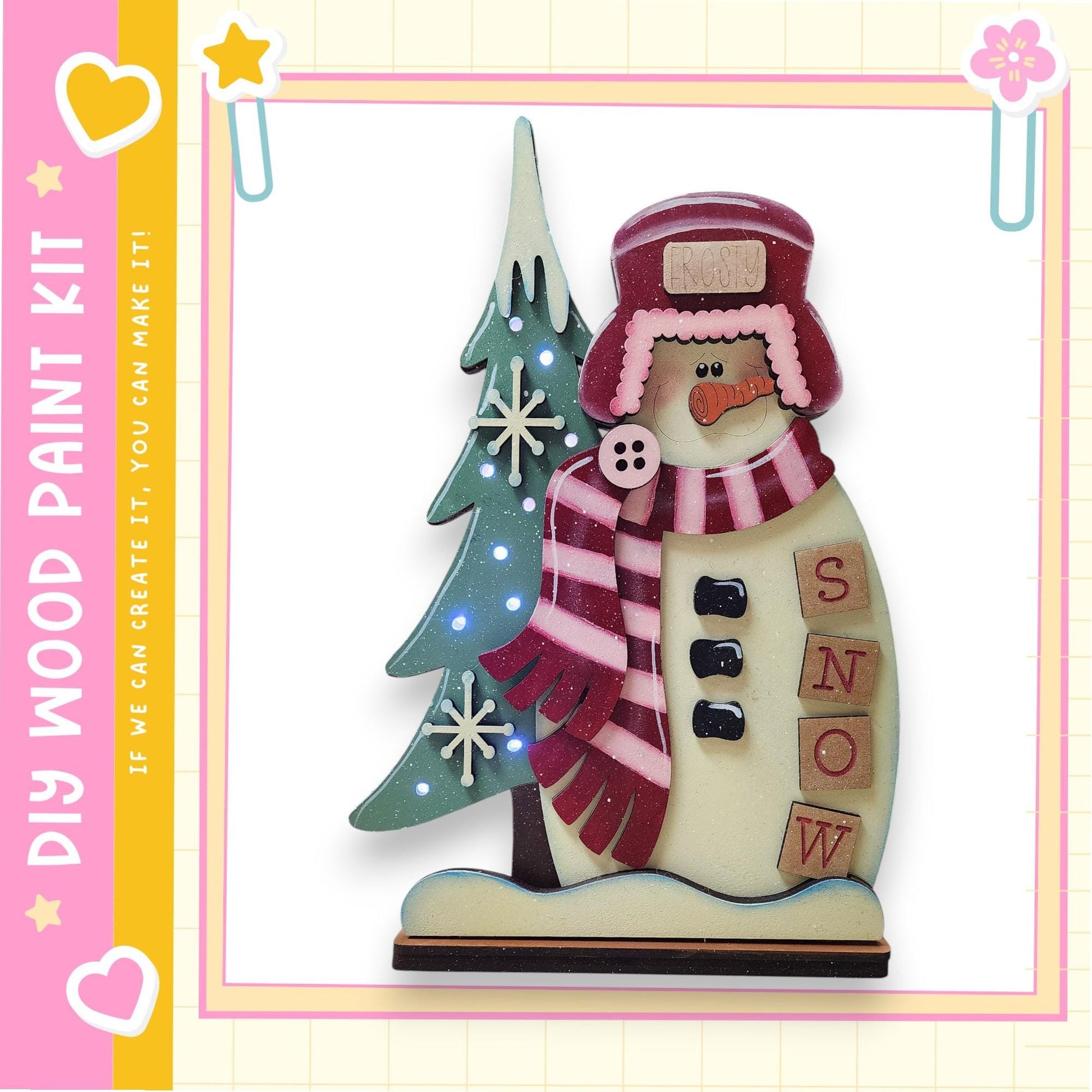 A wooden snowman figure with a red hat, scarf, and buttons, standing next to a decorated Christmas tree.