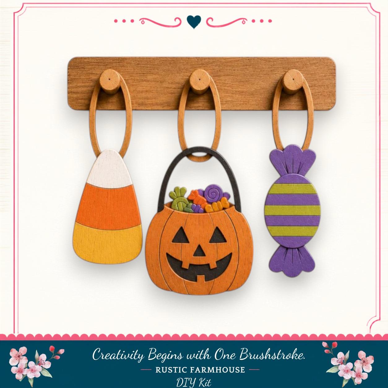 a Halloween-themed DIY kit, including a wooden board with three wooden rings hanging from it, each holding a different Halloween decoration: a candy corn, a carved pumpkin, and a candy cane.