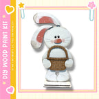 A wooden toy rabbit holding a basket, set against a pink and yellow background with decorative elements.
