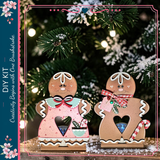two gingerbread cookies, each with a heart-shaped cutout, sitting on a wooden surface. The cookies are decorated with pink and green accents, and they appear to be homemade. The background is a blurred image of a Christmas tree, creating a festive atmosphere.