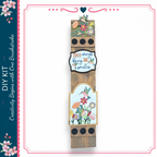 a wooden sign with a floral design and a motivational quote.