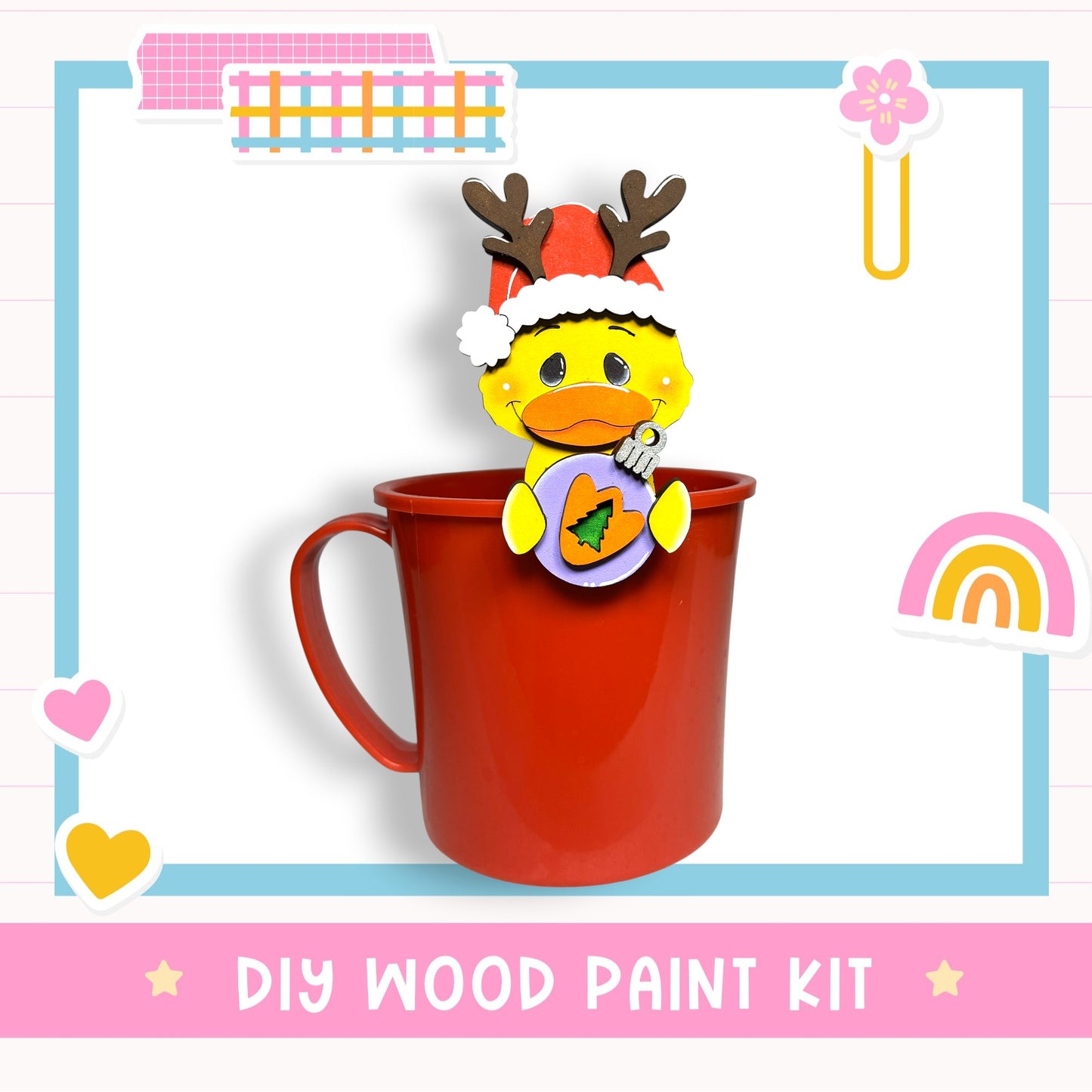 A red mug with a cartoon duck wearing a Santa hat and holding a Christmas ornament, surrounded by various colorful stickers and a "DIY WOOD PAINT KIT" label.