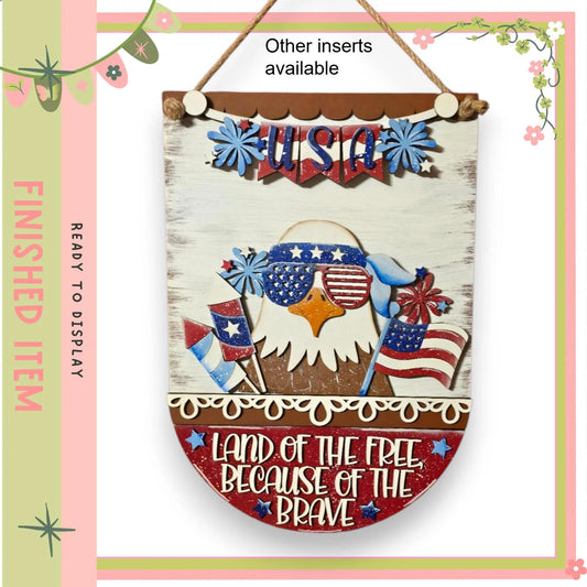 a patriotic banner with an eagle and American flags, along with the text "Land of the free because of the brave".