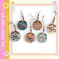 A collection of five wooden ornaments with various holiday-themed sayings hanging from strings.