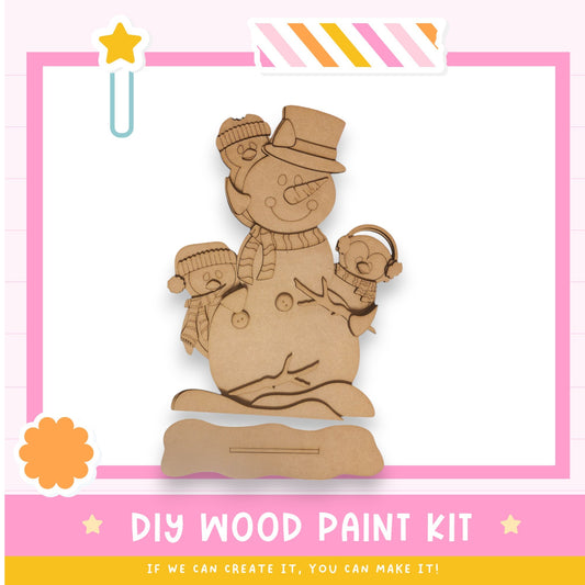 a wooden craft kit with a snowman holding a baby
