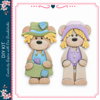 two cute teddy bears, one wearing a green hat and the other wearing a purple hat, both holding a small blue heart.