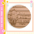 a wooden sign with the text "Welcome to our home" carved into it, along with a decorative design.