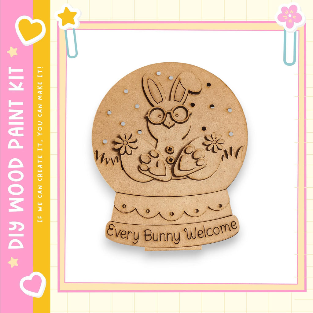 A wooden snow globe with a bunny inside, surrounded by flowers, and the text "Every Bunny Welcome" written on it.