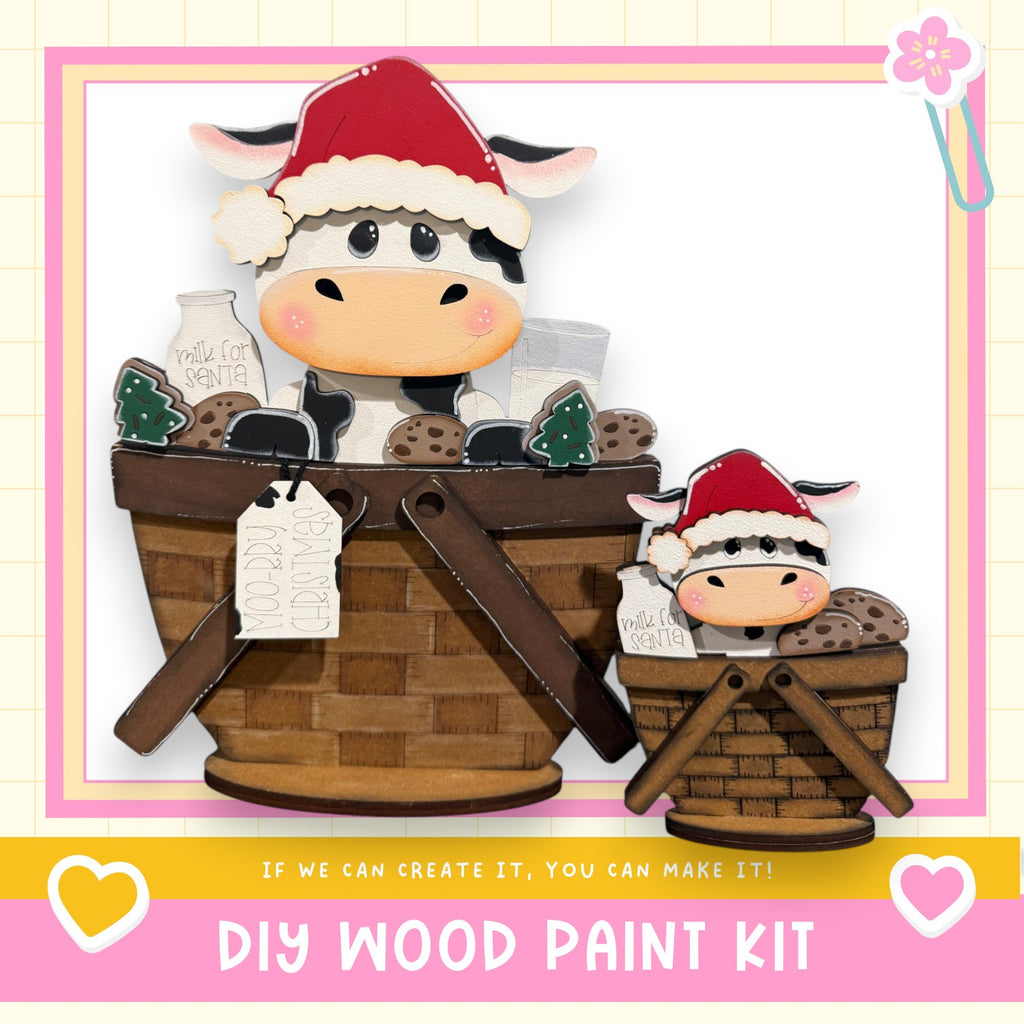 A wooden paint kit featuring two cow-shaped figures, one larger and one smaller, sitting in a basket. The kit appears to be made of wood and is labeled as a DIY wood paint kit.