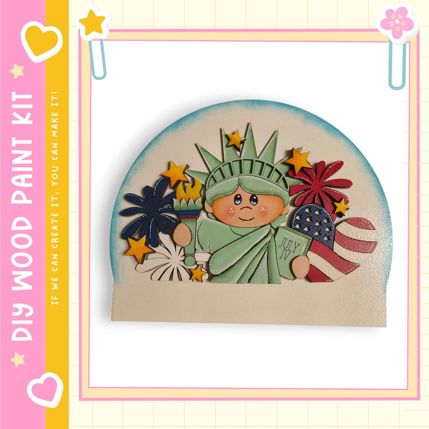 A wooden paint kit depicting the Statue of Liberty surrounded by various patriotic symbols, including a flag, fireworks, and a heart.