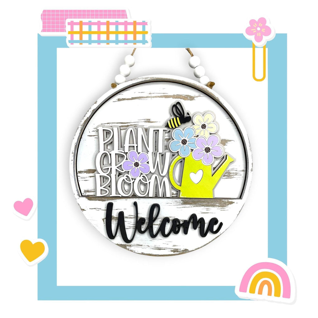 a picture of a welcome sign with flowers and a bee