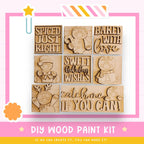 The image is a DIY wood paint kit featuring various wooden shapes and characters, including a star, a gingerbread man, and a cat.
