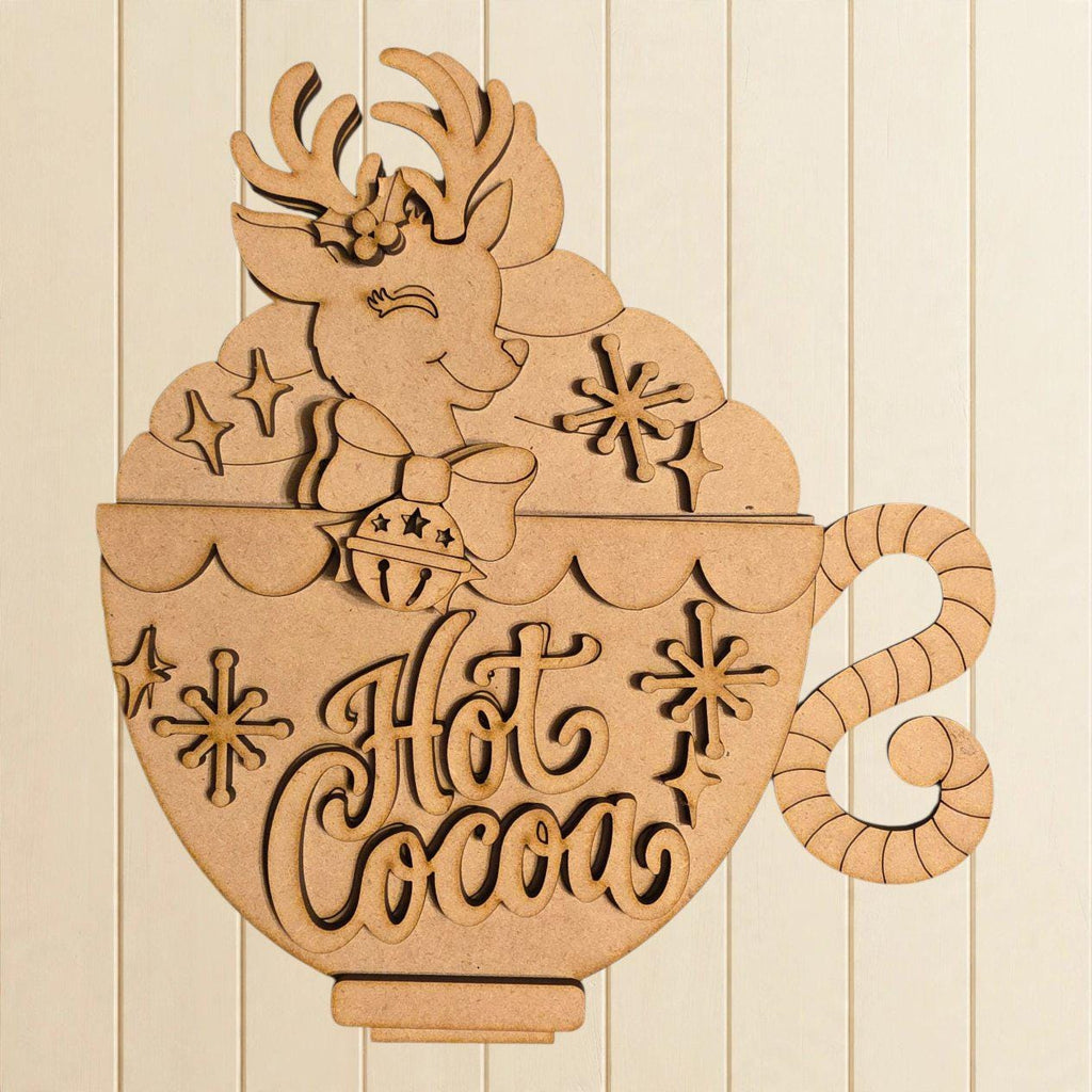 A wooden cutout of a cup with a reindeer and snowflakes, along with the text "Hot Cocoa" written on it.