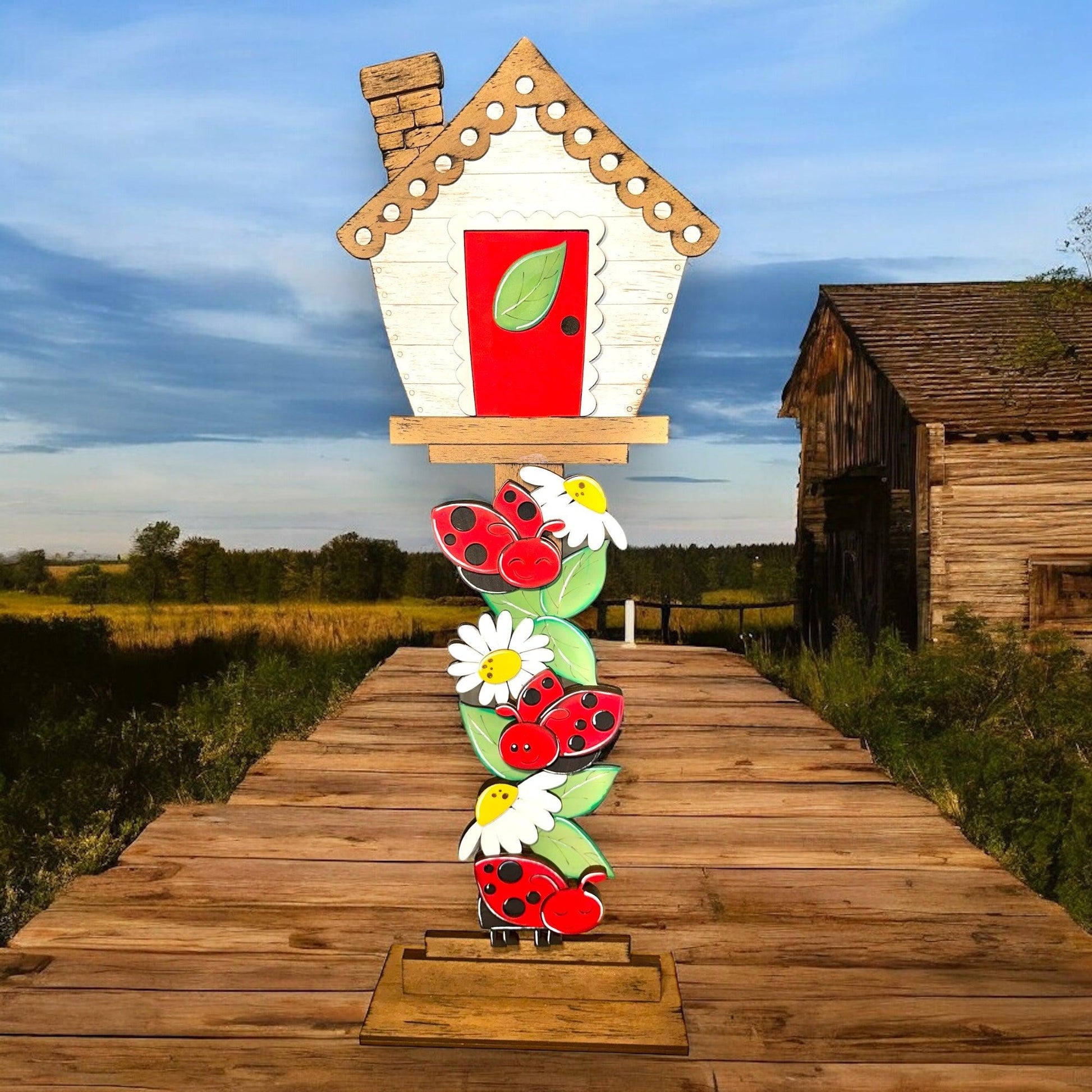 a wooden walkway with a house and flowers on it