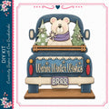 A wooden truck decorated with a teddy bear and snowflakes, with the text "Warm Winter Wishes" displayed on the truck.