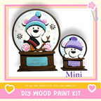 a DIY wood paint kit for creating a winter wonderland-themed snow globe. The kit includes a snow globe with a bear wearing a hat and a miniature snow globe with a bear wearing a hat. The kit is designed to allow users to create their own winter wonderland-themed snow globes.