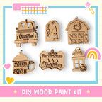 a DIY wood paint kit with various wooden ornaments and decorations, including a Christmas tree, a barn, a house, a mug, and a birdhouse.