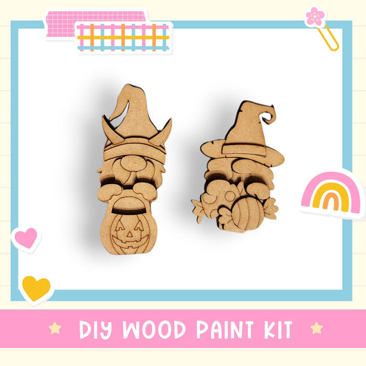 two wooden gnome-shaped cutouts, one with a carved pumpkin and the other with a carved skull, set against a white background with a pink border.