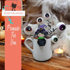 a mug with eyes and a witch on it
