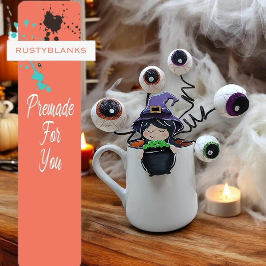 a mug with eyes and a witch on it