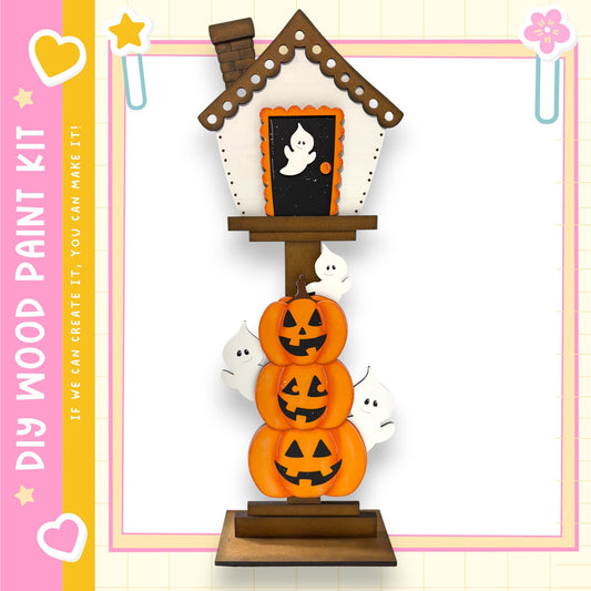 A Halloween-themed wooden house with a chimney, decorated with jack-o-lanterns and ghost figures.