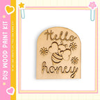 a wooden cutout with the text "Hello honey" carved into it, surrounded by a decorative border.
