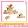 a DIY wood paint kit with a focus on creating a wooden cutout of a leprechaun. The kit includes a wooden cutout of a leprechaun, a tag with the word "Lucky Me", and a heart-shaped tag. The kit is presented in a pink and yellow frame, and the text encourages viewers to "If we can create it, you can make it!"