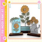 a wooden paint kit with a focus on creating decorative pieces, including a blue sign with a sunflower and a gray watering can.