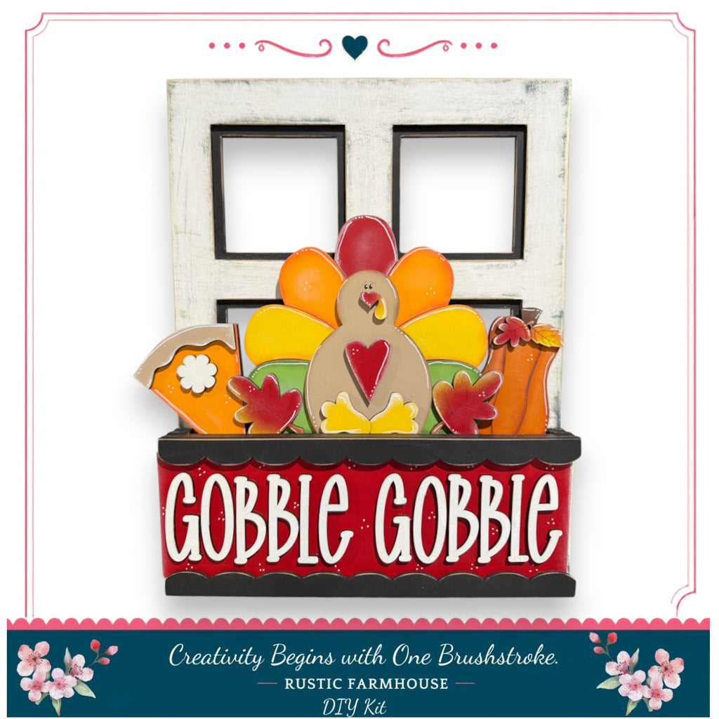 A Thanksgiving-themed DIY kit featuring a wooden frame with a turkey decoration, a pumpkin, and other fall-themed elements. The kit is labeled as "Creativity Begins with One Brushstroke - Rustic Farmhouse - DIY Kit".