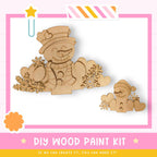 a DIY wood paint kit for creating wooden snowmen, with a pink and white striped border and a star decoration.