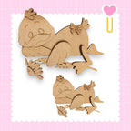 two wooden cutouts of cartoon-like animals, one larger and one smaller, set against a pink background with a heart shape.