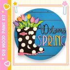 a colorful and whimsical sign that reads "Welcome Spring" with a polka dot boot and a bouquet of flowers as the main decorative elements.