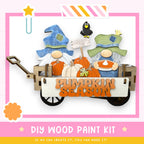 a DIY wood paint kit for creating a pumpkin season decoration, with two gnomes in a wagon holding pumpkins and a sign that says "Pumpkin Season".