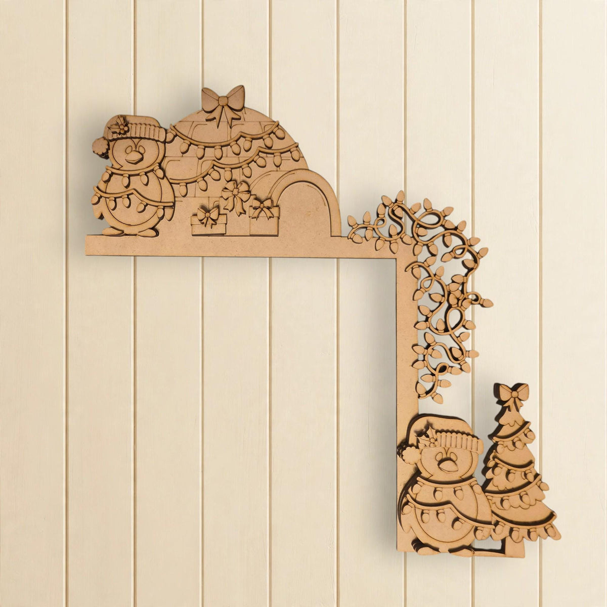 A wooden Christmas decoration with a snowman, a tree, and other holiday-themed elements.